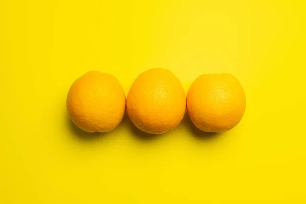 Top view of natural oranges on yellow background — Fotografia de Stock