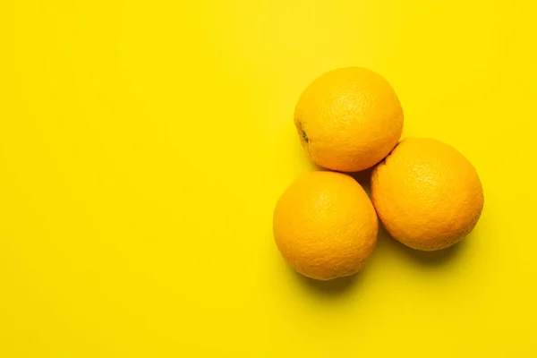 Vista superior de naranjas tropicales sobre fondo amarillo - foto de stock