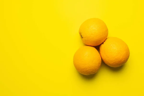 Vista dall'alto delle arance tropicali su sfondo giallo — Foto stock