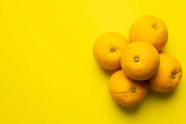 Vista superior de laranjas suculentas na superfície amarela com espaço de cópia — Fotografia de Stock
