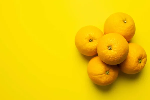 Top view of juicy oranges on yellow surface with copy space - foto de stock