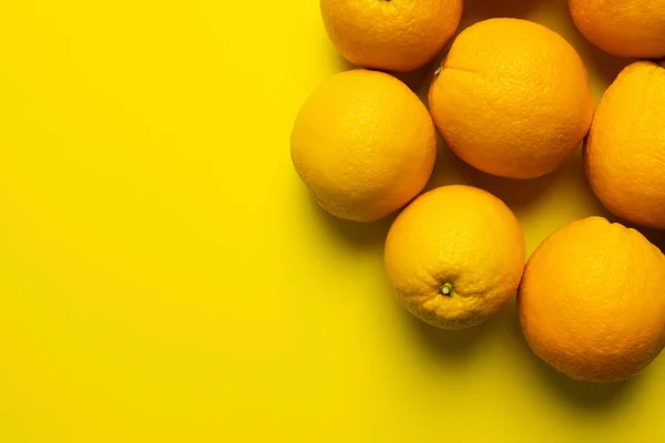 Draufsicht auf reife Orangen in Schale auf gelbem Hintergrund — Stockfoto