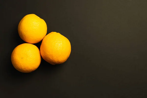 Top view of sweet oranges isolated on black - foto de stock