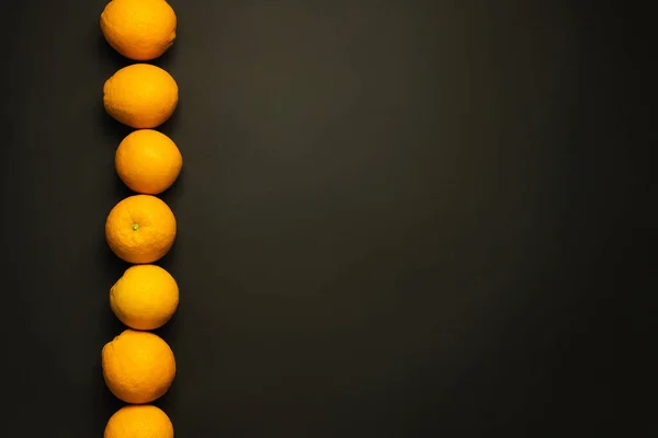 Top view of fresh oranges in line on black background — Stockfoto