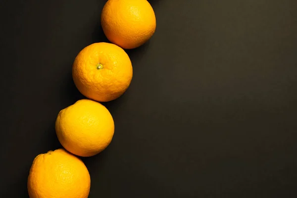 Flat lay com laranjas brilhantes no fundo preto com espaço de cópia — Fotografia de Stock