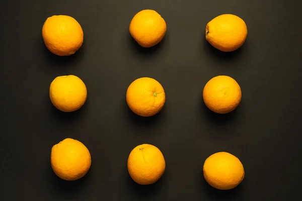 Flache Lage mit natürlichen Orangen auf schwarzem Hintergrund — Stockfoto