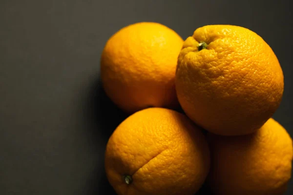 Close up view of fresh oranges on black background — Photo de stock