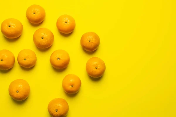 Vista superior de mandarinas maduras y orgánicas sobre fondo amarillo - foto de stock