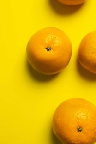 Top view of bright tangerines on yellow background — Fotografia de Stock