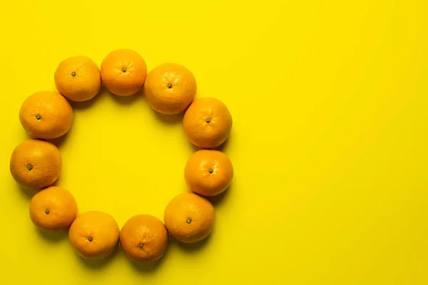 Vista superior do quadro de tangerinas doces com sombra no fundo amarelo — Fotografia de Stock