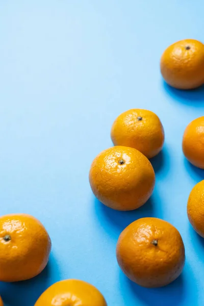 High angle view of natural tangerines with shadow on blue background — Fotografia de Stock