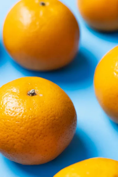 Vista de cerca de mandarinas en cáscara sobre fondo azul - foto de stock