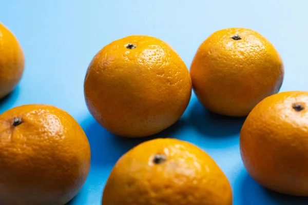 Vista de cerca de mandarinas maduras sobre fondo azul - foto de stock