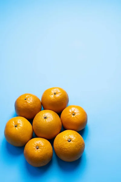 Colocación plana con mandarinas maduras con sombra sobre fondo azul - foto de stock