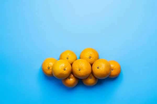 Top view of natural tangerines on blue background — Stock Photo