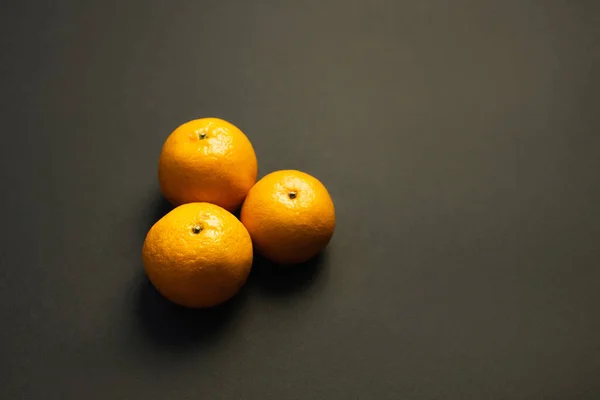 Vista de ángulo alto de sabrosas mandarinas sobre fondo negro - foto de stock