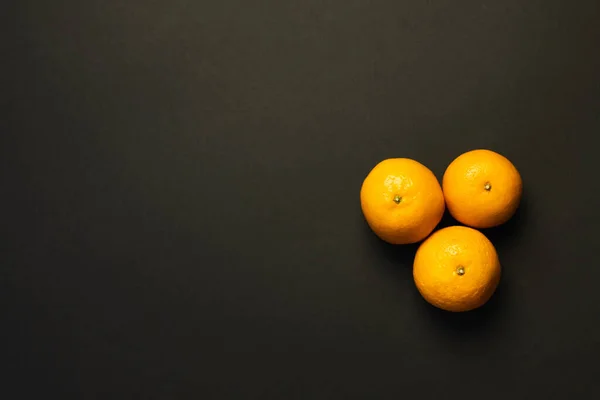 Vista superior de tangerinas frescas isoladas em preto com espaço de cópia — Fotografia de Stock