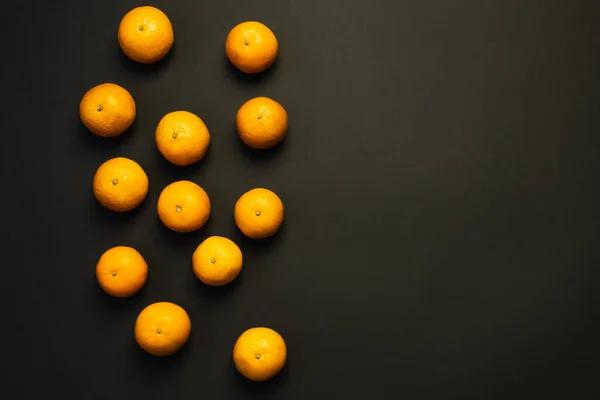 Top view of whole tangerines on black background — Stockfoto