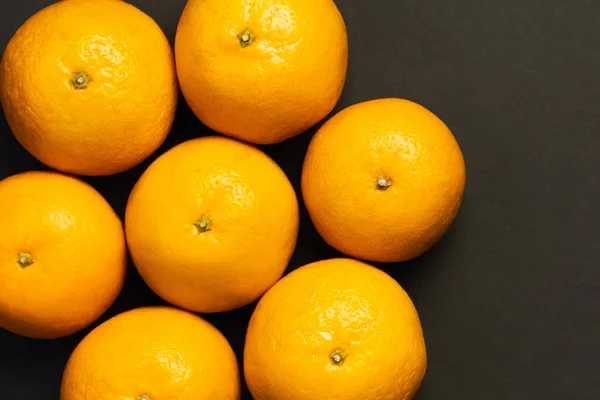 Colocación plana con mandarinas naturales en forma redonda aisladas en negro - foto de stock