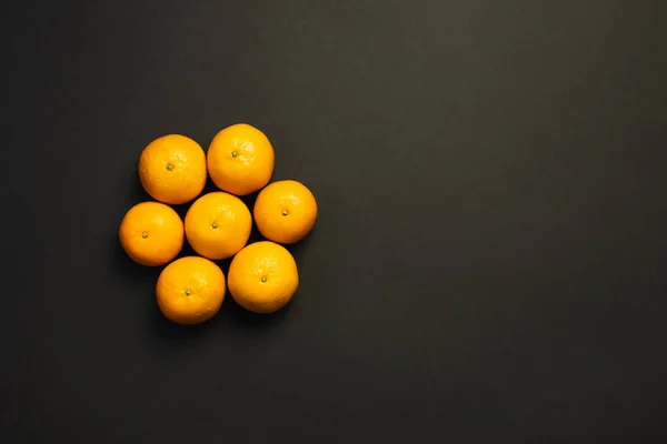 Plancha plana de mandarinas en forma redonda aislada en negro - foto de stock