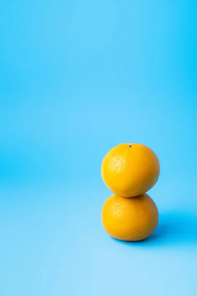 Вкусные мандарины на синем фоне с копировальным пространством — стоковое фото