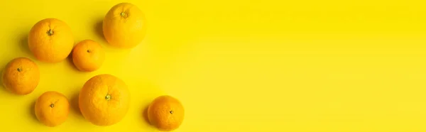 Top view of ripe mandarins and oranges on yellow background, banner — Foto stock