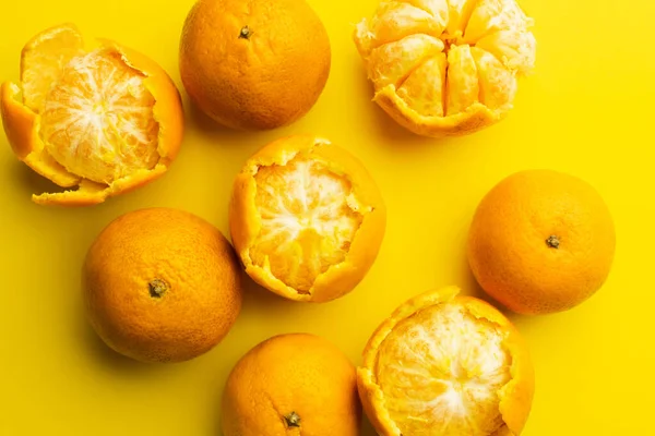 Верхний вид органических мандаринов в кожуре на желтом фоне — стоковое фото