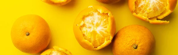 Top view of sweet tangerines in peel on yellow background, banner — Stock Photo