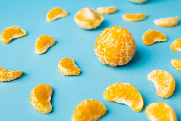 Vue rapprochée des mandarines pelées sur fond bleu — Photo de stock
