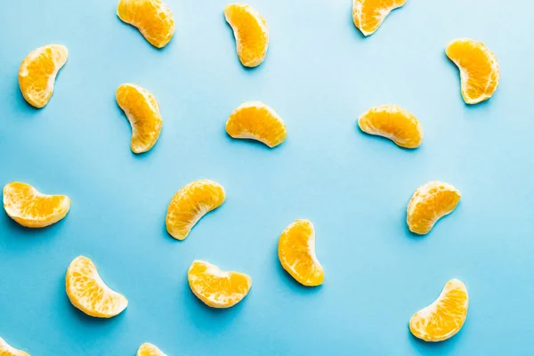 Vista superior dos lóbulos de tangerina no fundo azul — Fotografia de Stock