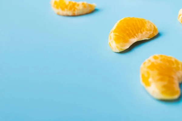 Vue rapprochée des lobules de mandarine mûre sur fond bleu — Photo de stock