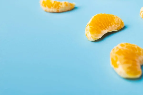 Close up view of lobules of ripe mandarin on blue background — Stock Photo