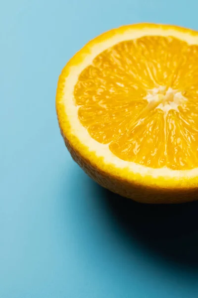 Vista de cerca de jugoso y corte naranja sobre fondo azul — Stock Photo