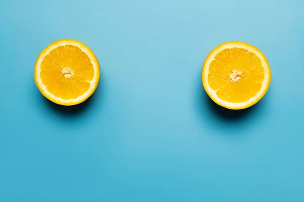 Top view of bright and cut orange on blue background — Stock Photo