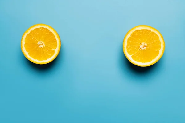 Vue de dessus d'orange vif et coupé sur fond bleu — Photo de stock