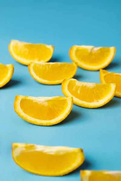 Close up view of cut orange pieces on blue background - foto de stock