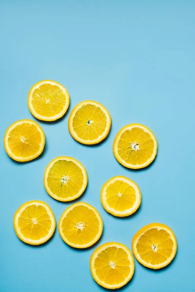 Top view of slices of sweet orange on blue background — Fotografia de Stock
