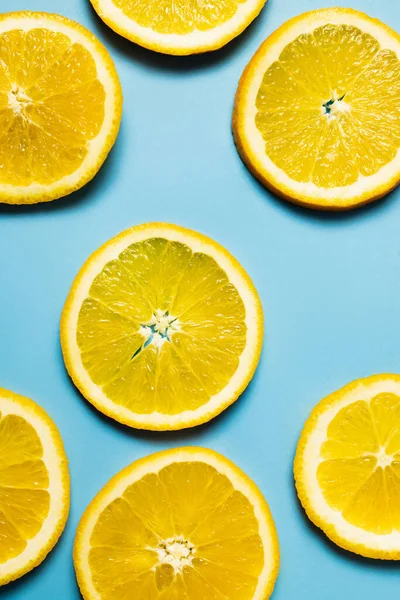 Top view of natural orange slices on blue background - foto de stock