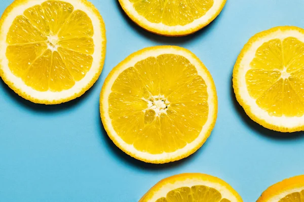 Top view of natural orange slices on blue background - foto de stock