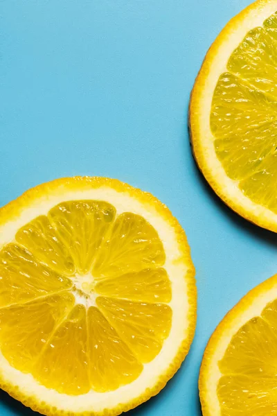 Close up view of organic orange slices on blue background — Fotografia de Stock