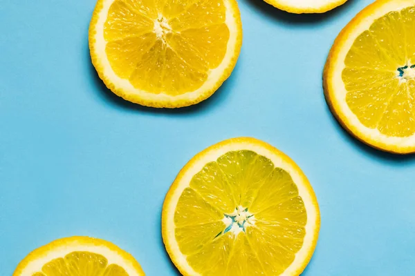 Top view of slices of ripe orange on blue background — Fotografia de Stock