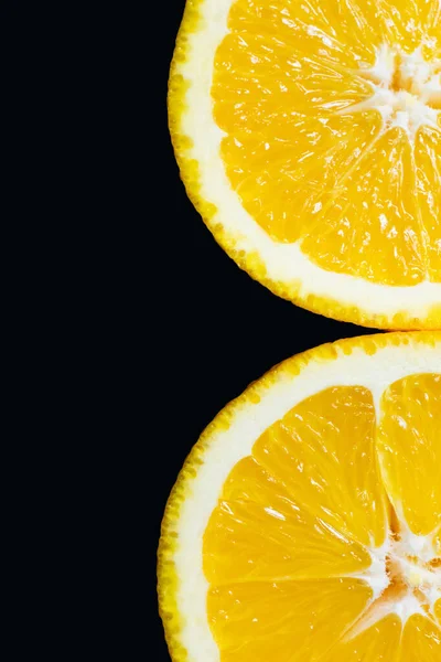 Close up view of slices of tasty orange isolated on black - foto de stock