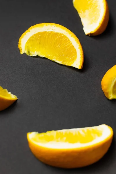 Close up view of pieces of natural orange on black background — Fotografia de Stock