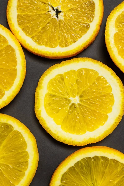 Close up view of slices of tropical oranges on black background — Fotografia de Stock