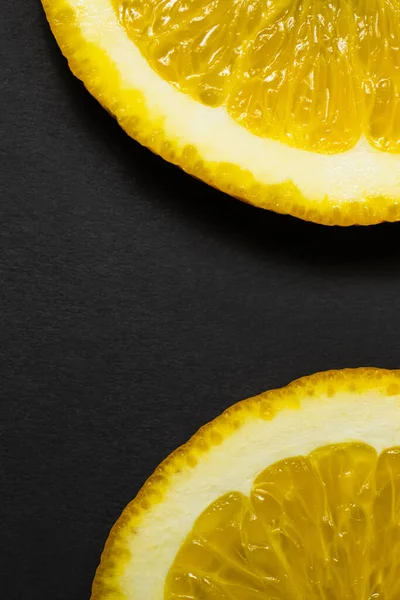 Close up view of natural orange slices on black background — Foto stock