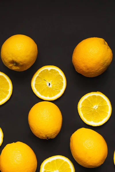 Вид зверху цілі і скибочки апельсинів ізольовані на чорному — стокове фото