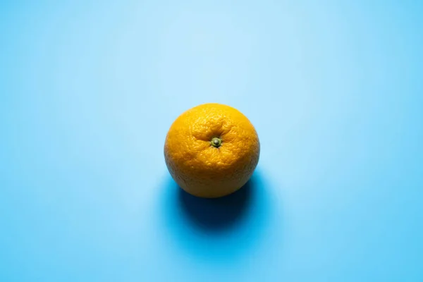 Top view of whole orange with shadow on blue background — Photo de stock