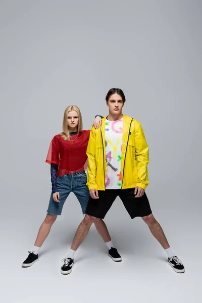 Fashionable couple in sneakers posing on grey background — Photo de stock