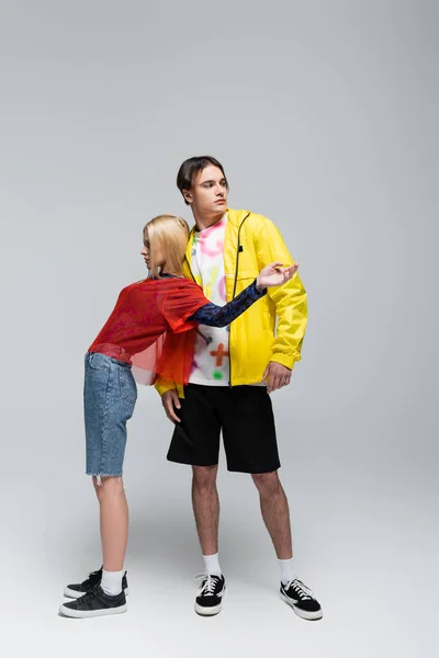 Blonde woman posing near stylish man on grey background — Photo de stock