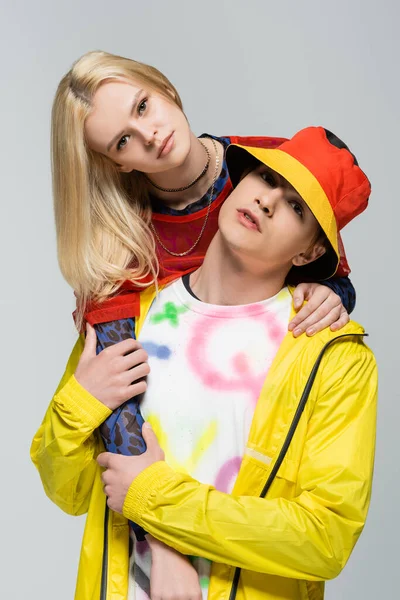 Portrait of stylish couple in bright clothes looking at camera isolated on grey — Stock Photo